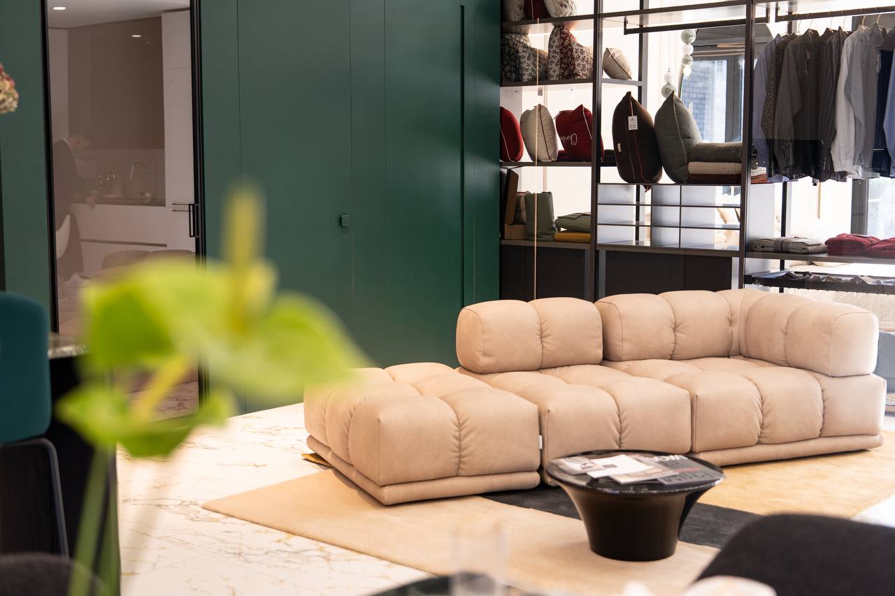 Włoski salon Bellissimo Home — modułowa sofa na tle głębokiej zieleni w showroomie we Wrocławiu