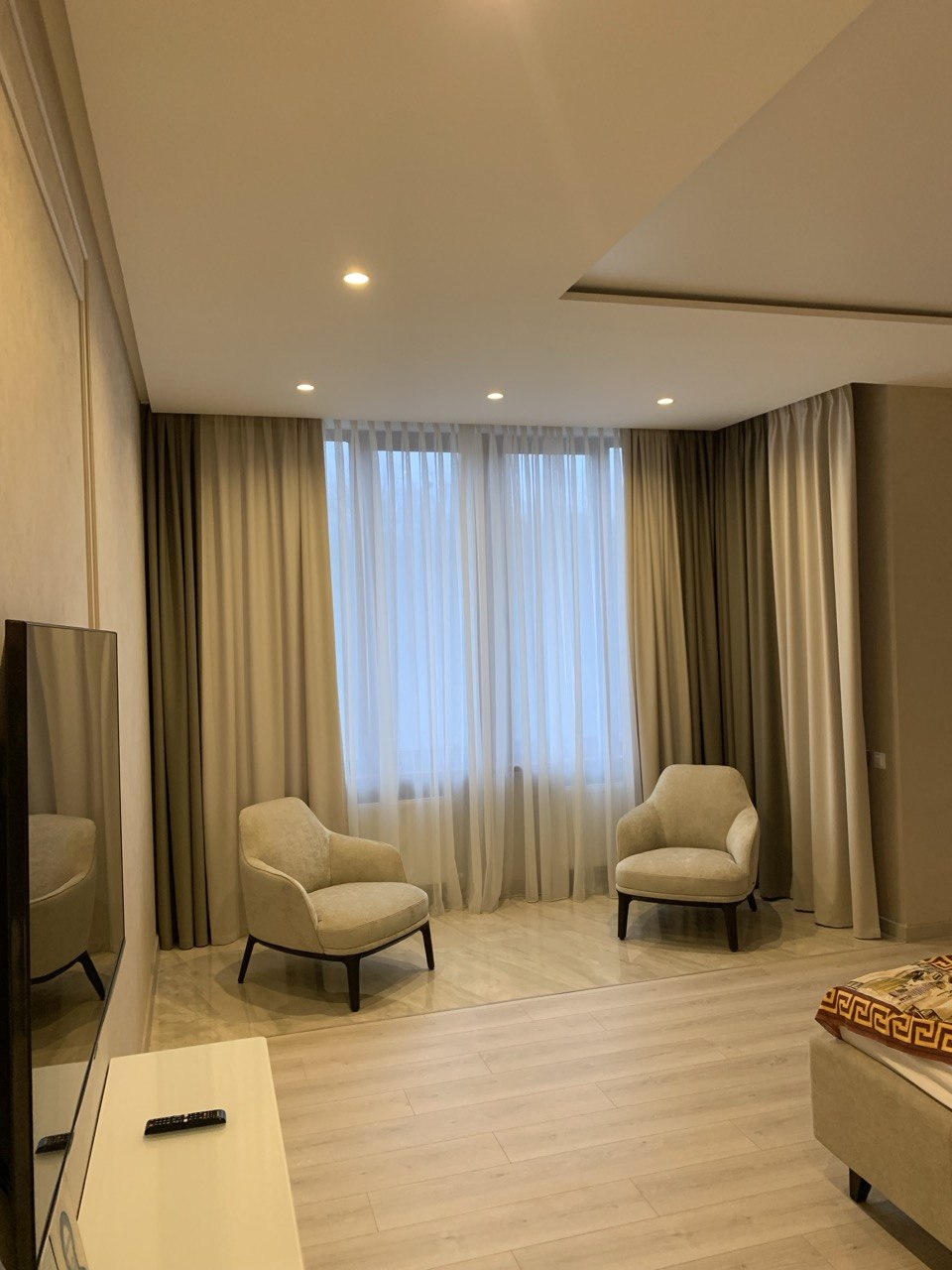 Strefa wypoczynkowa w sypialni: dwa fotele przy oknie z zasłonami — realizacja Bellissimo Home.